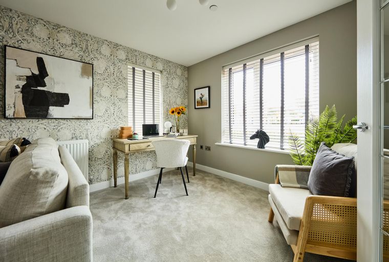 A home office with a desk, chair, and windows.