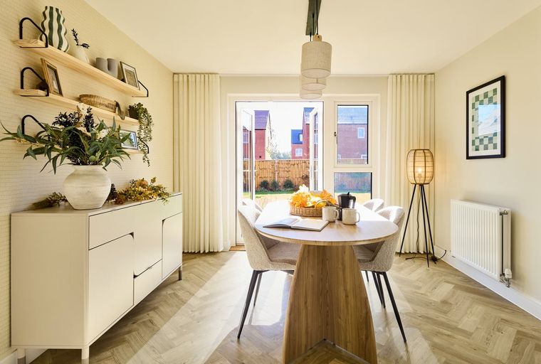 A dining room with a table, chairs, sideboard, and shelves.