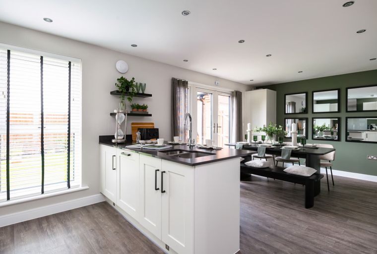 A modern kitchen and dining area with an island, dining table, and chairs.