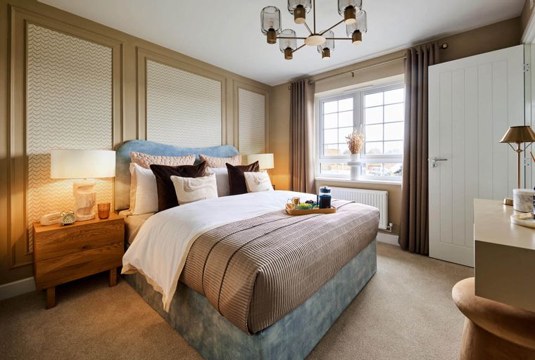 A bedroom with a bed, bedside tables, a window, and a chandelier.