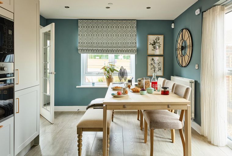 A dining area with a table, chairs, and a bench set for breakfast.