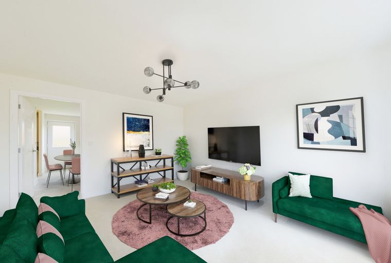 A living room with a green sectional sofa, a chaise lounge, coffee tables, and a television.