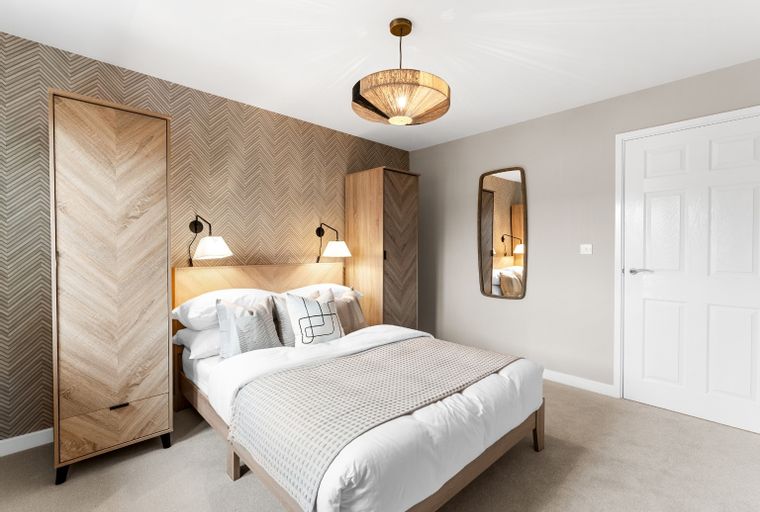 A bedroom with a bed, wardrobes, and a mirror.