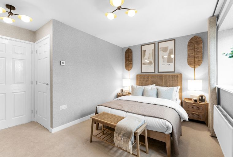 A bedroom with a bed, bedside tables, and a bench.