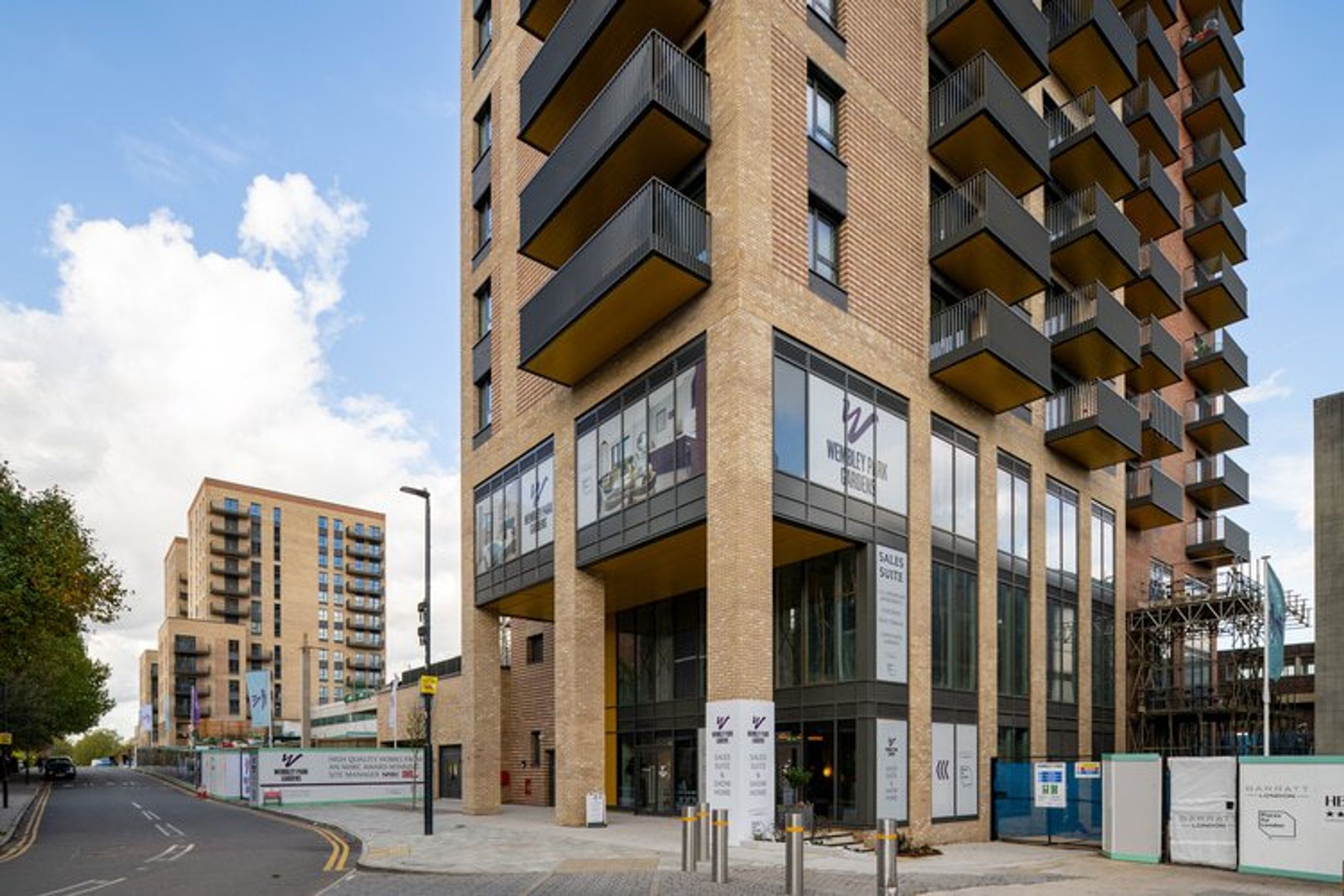 A modern apartment building with balconies and a sales suite on the ground floor.