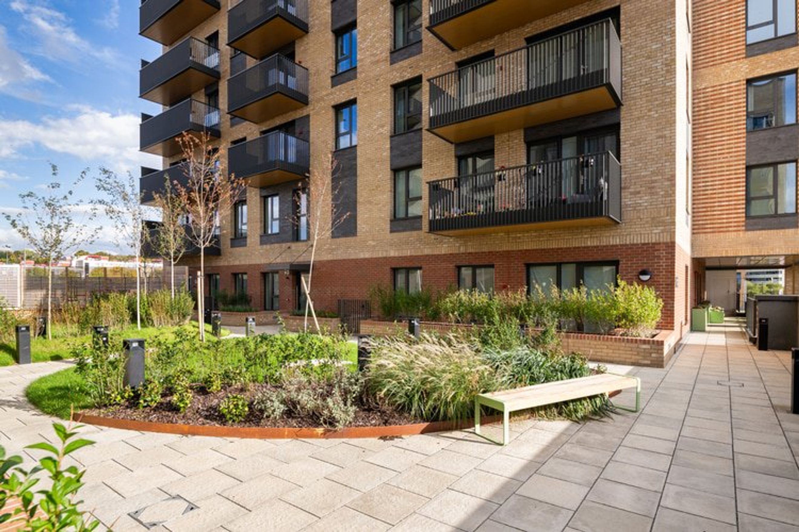 A modern apartment building with a landscaped courtyard and balconies.