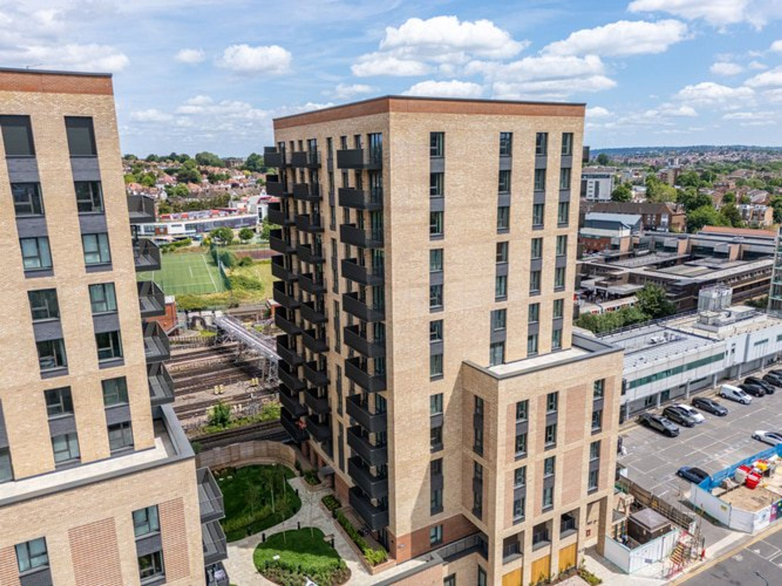 A modern apartment building with balconies and surrounding urban landscape.