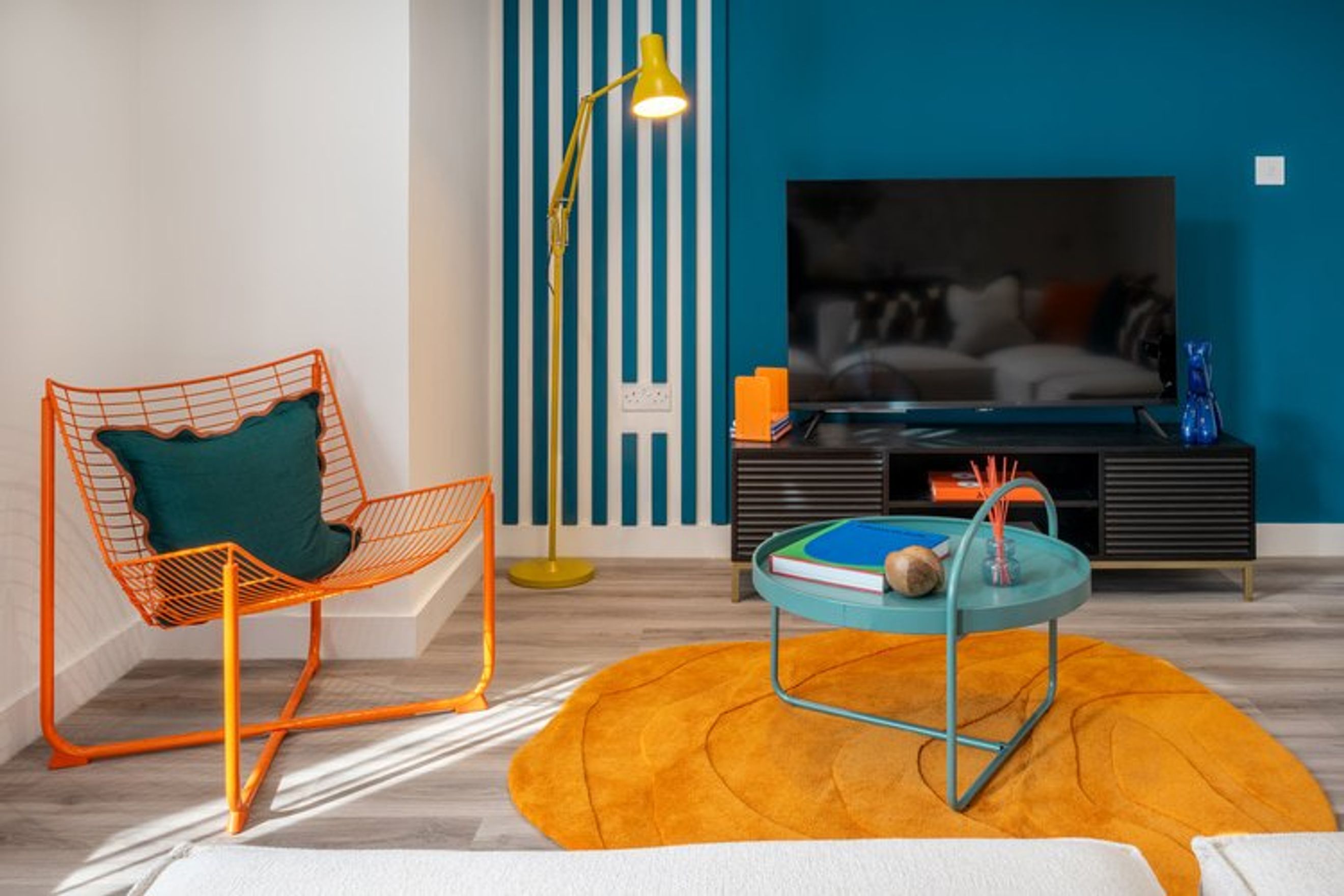 A living room with an orange chair, a TV, and a coffee table.