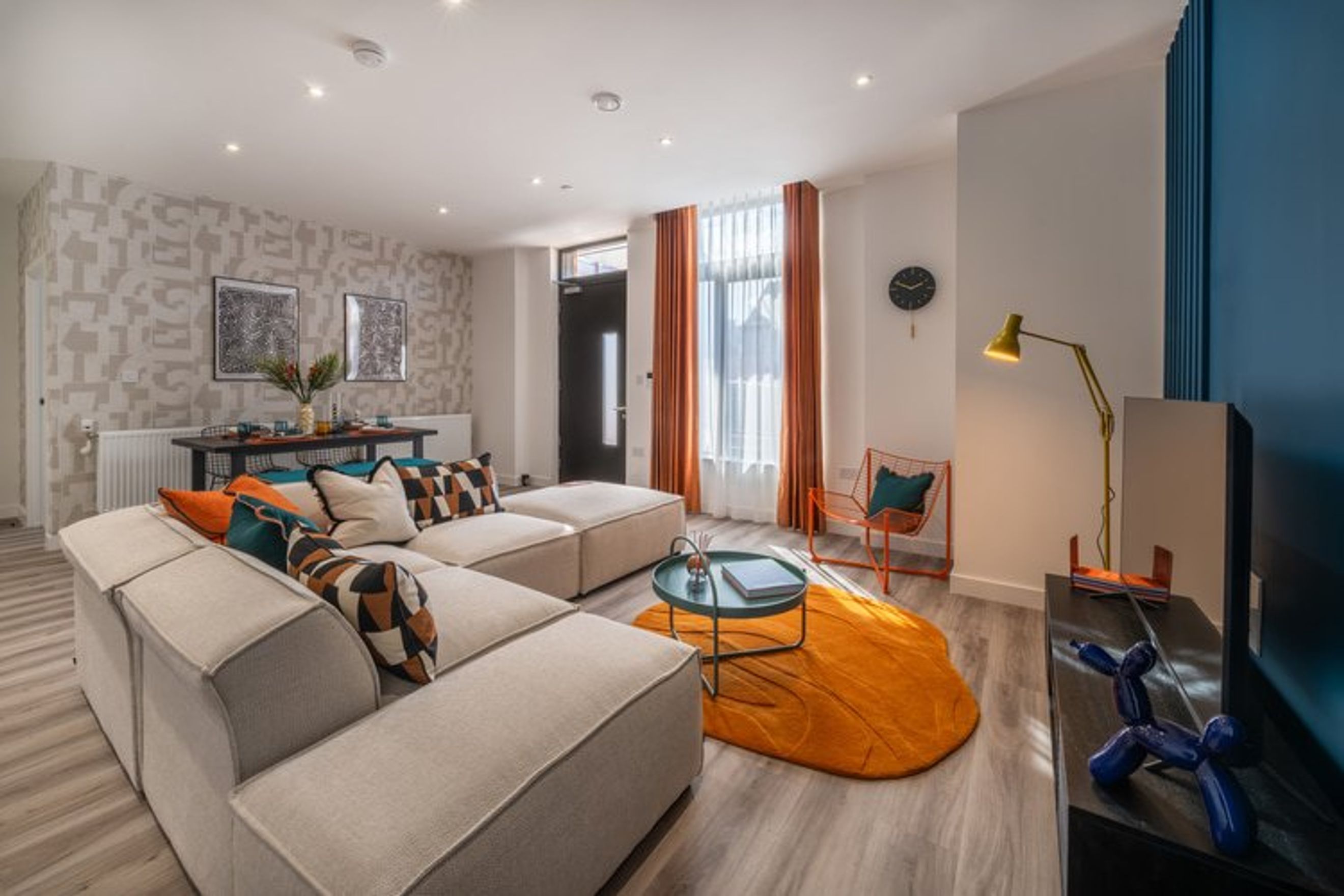 A living room with a sectional sofa, coffee table, and dining area.