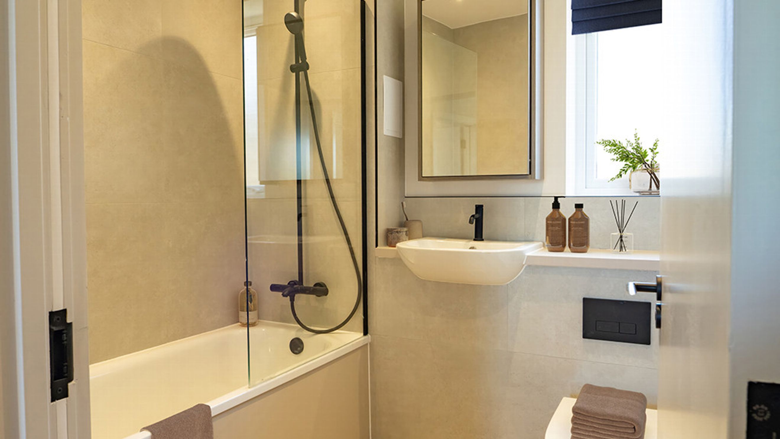 A bathroom with a bathtub, shower, sink, mirror, and toilet.