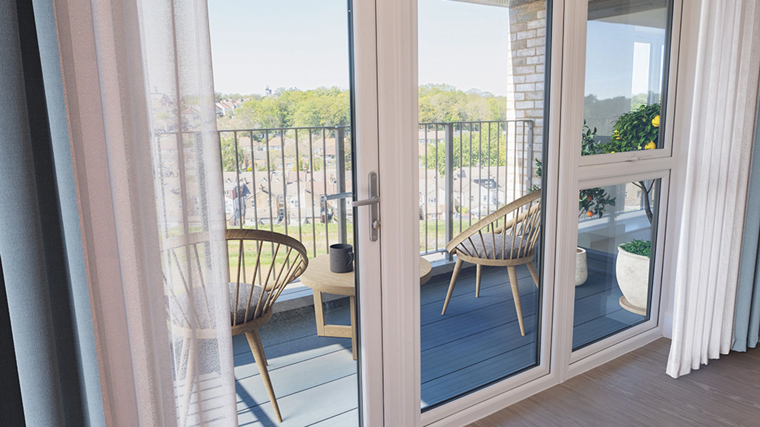 A balcony with two chairs and a table viewed through French doors.