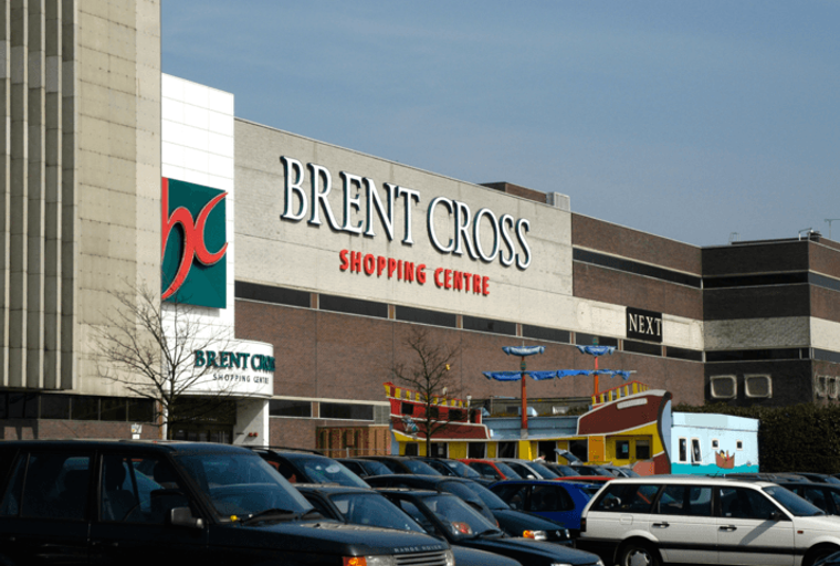 A shopping centre with cars parked in front.