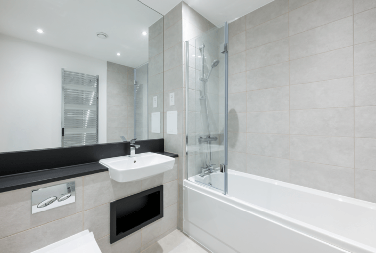 A bathroom with a sink, bathtub, and mirror.