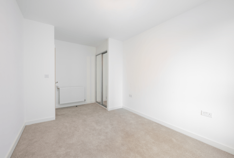 A bedroom with a radiator and a wardrobe.