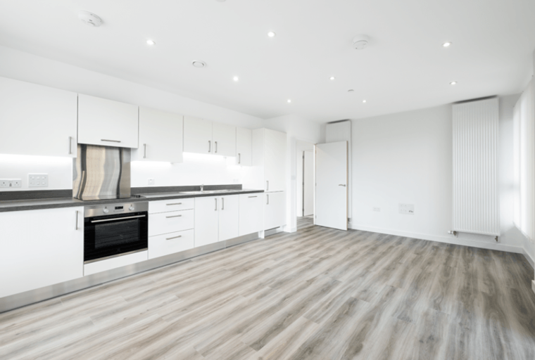 A modern kitchen with white cabinets, a dark countertop, and an oven.