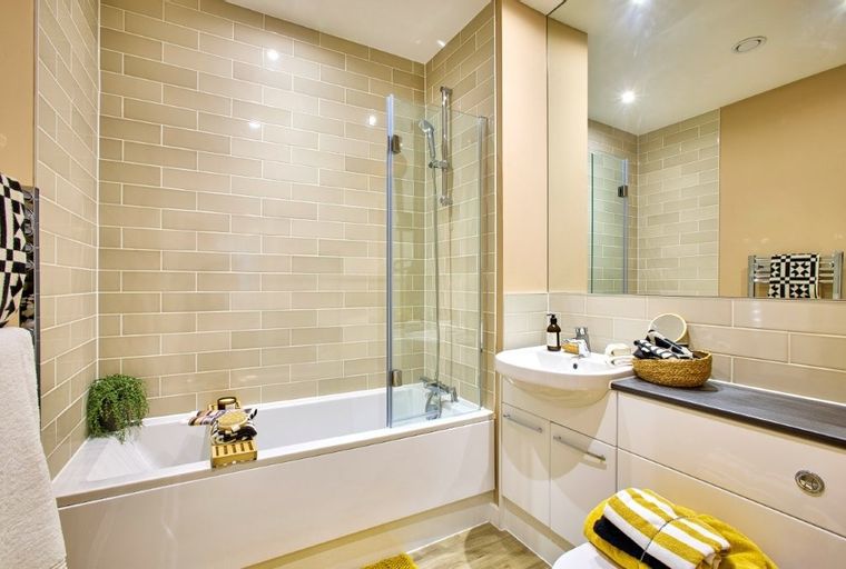 A bathroom with a bathtub, shower, sink, and vanity.