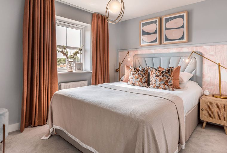 A bedroom with a bed, pillows, curtains, and a window.