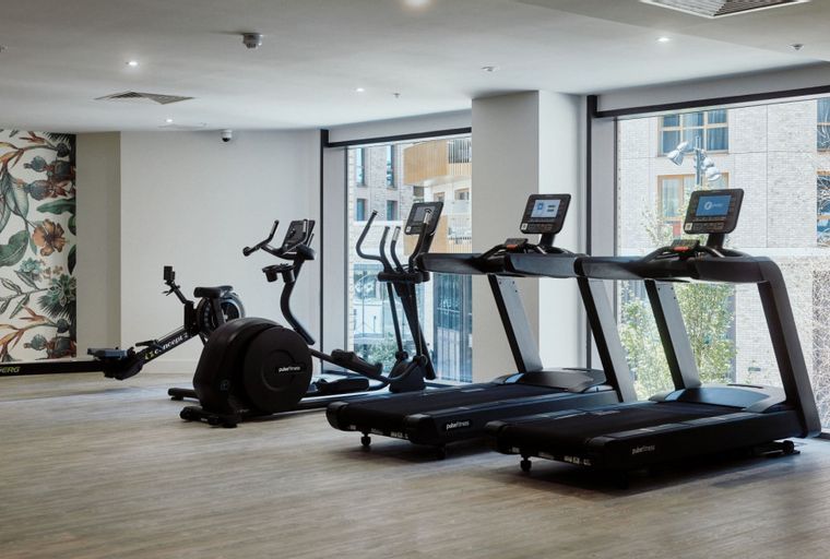 A gym with treadmills, an elliptical, and a rowing machine.