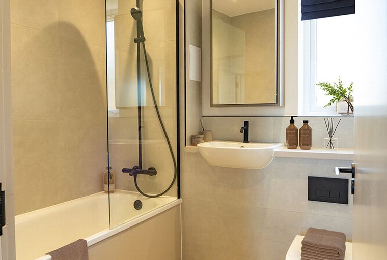 A bathroom with a bathtub, shower, sink, mirror, and toilet.
