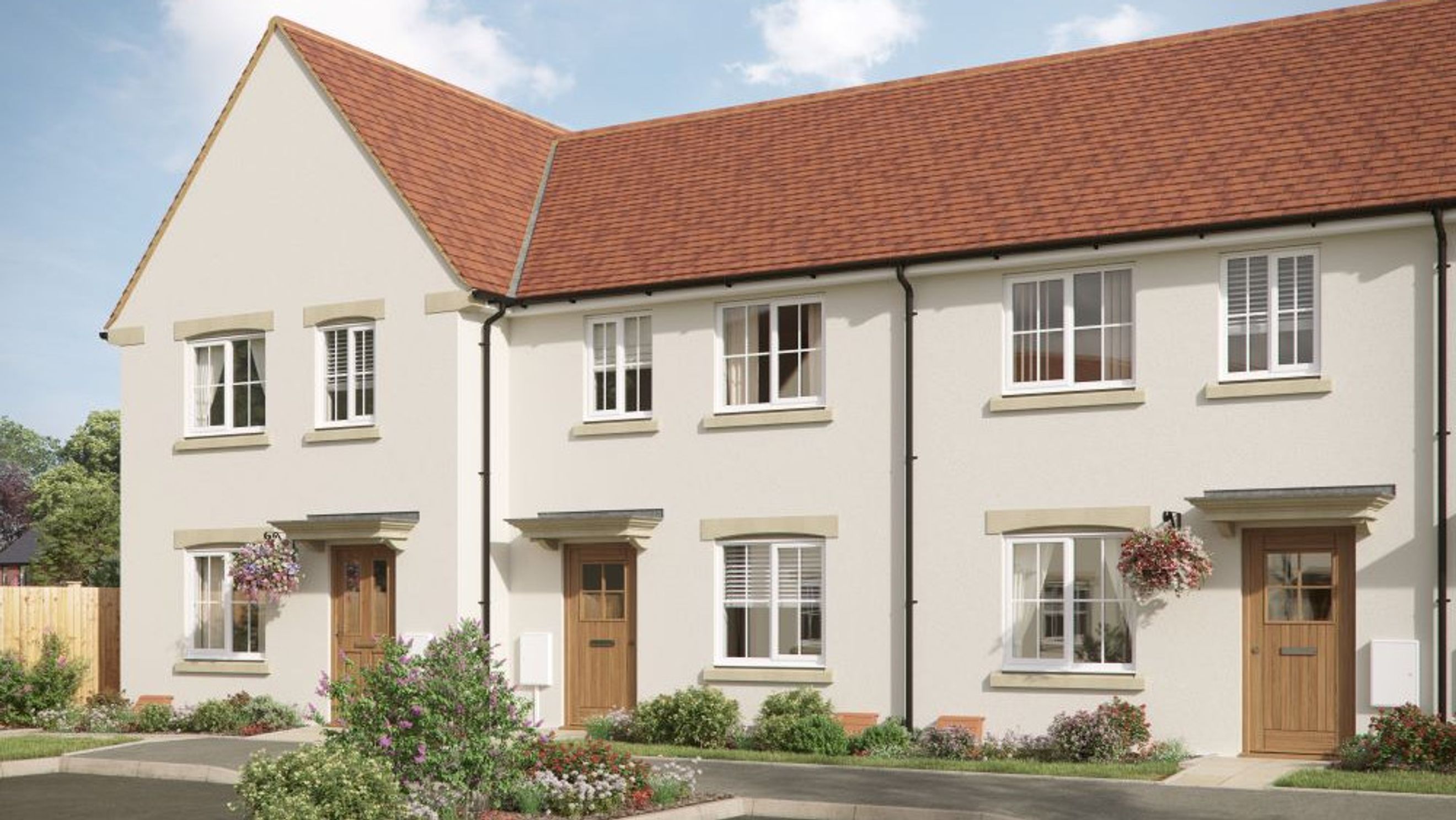 A row of modern townhouses with red tile roofs and light-colored exteriors.