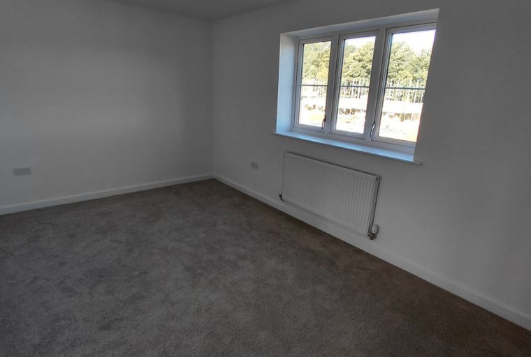 A bedroom with a window and a radiator.