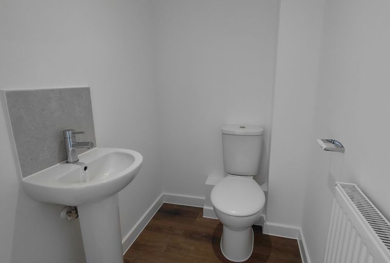 A bathroom with a sink, toilet, and radiator.