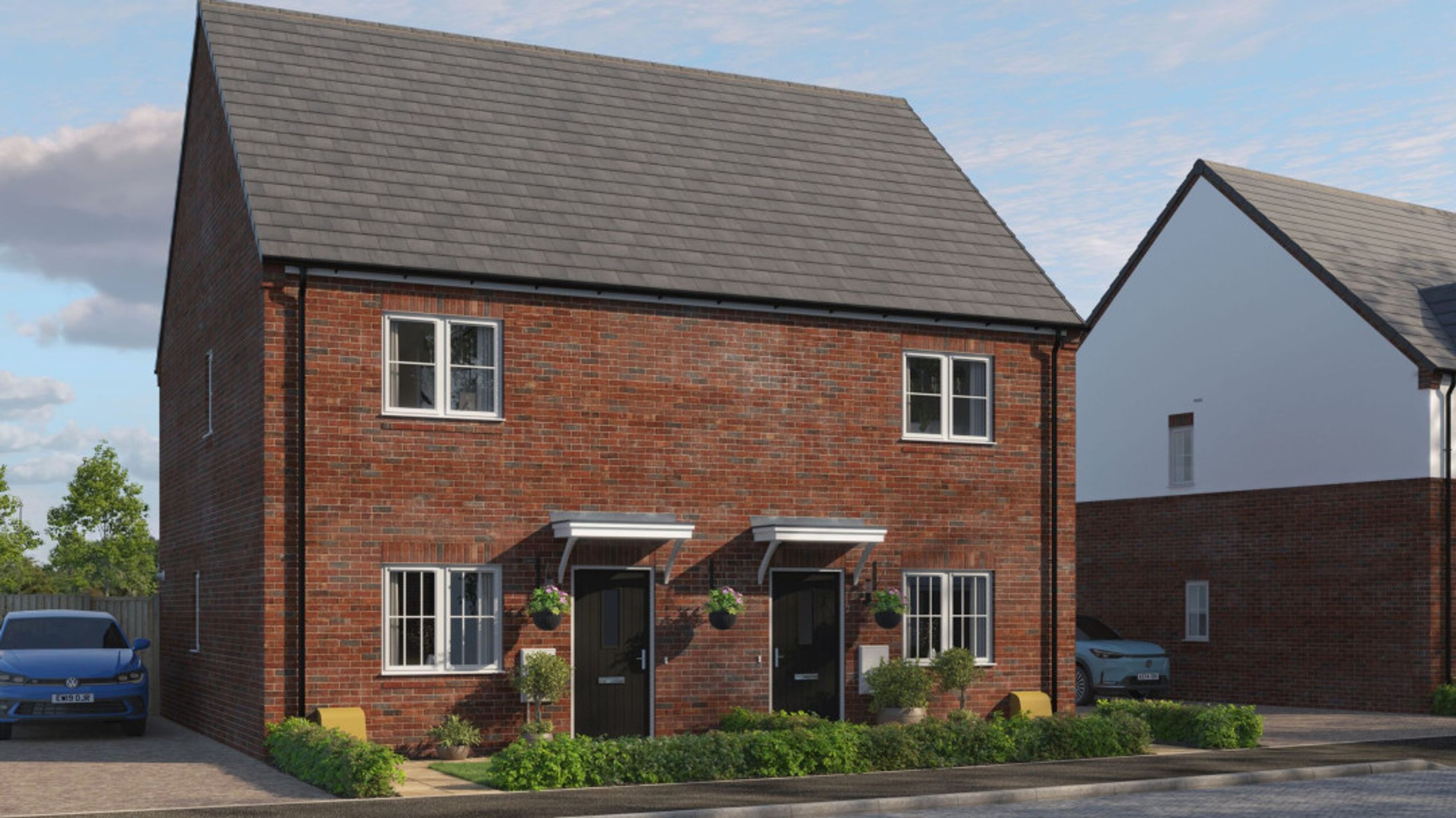 A pair of red brick semi-detached houses with grey tiled roofs and white-framed windows.