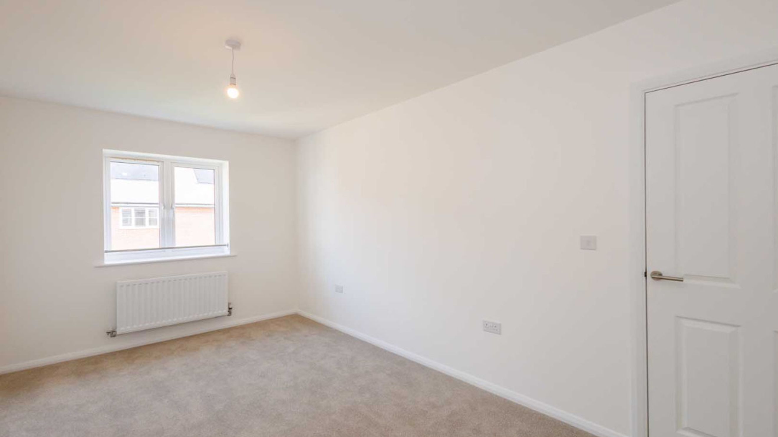 A bedroom with a window and a radiator.