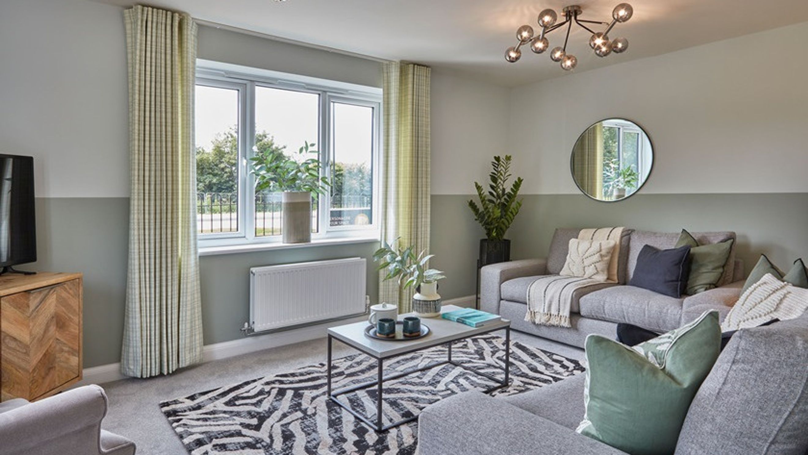 A living room with a sofa, coffee table, rug, and window.