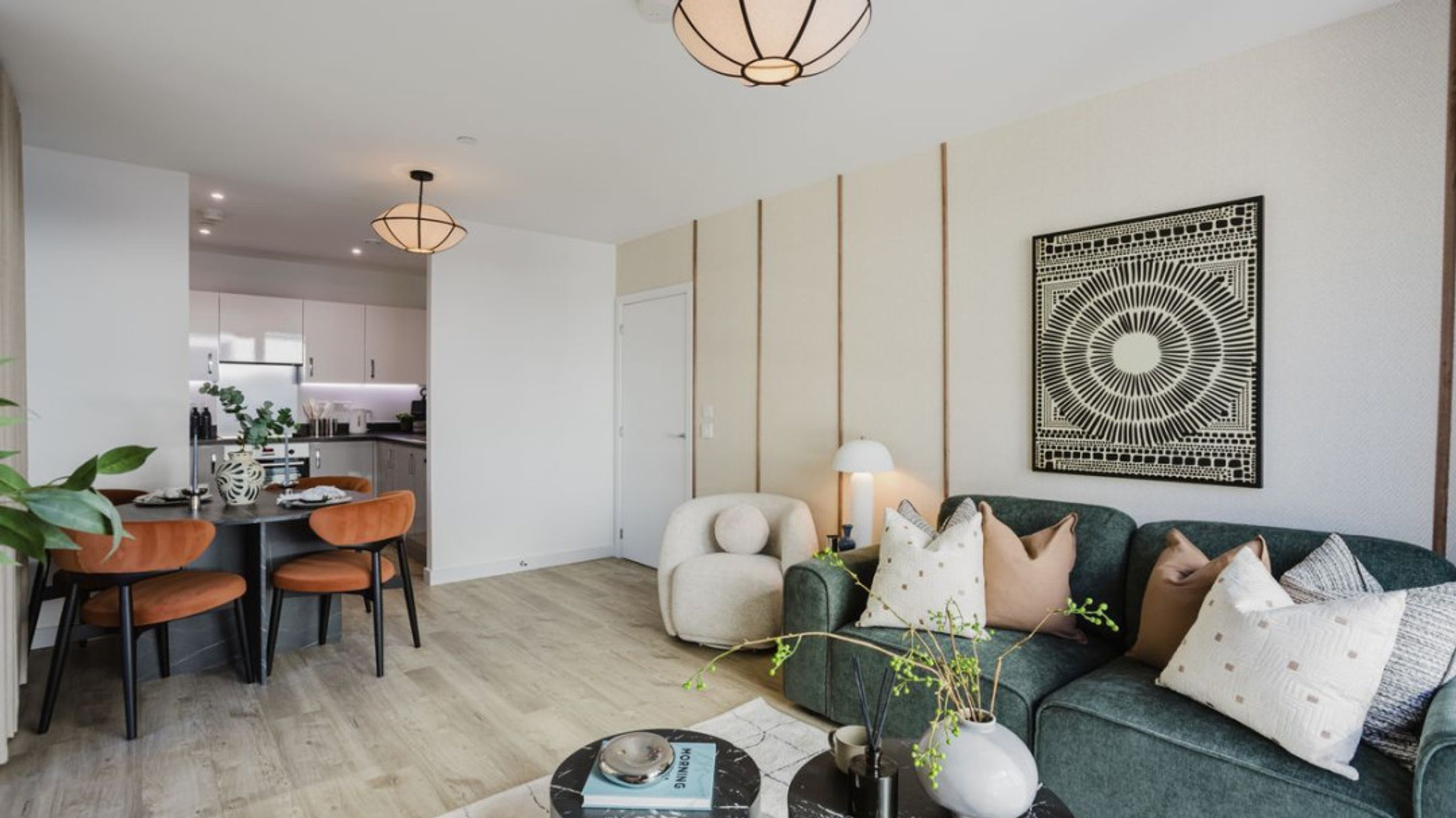 A living room and dining area with a kitchen in the background.
