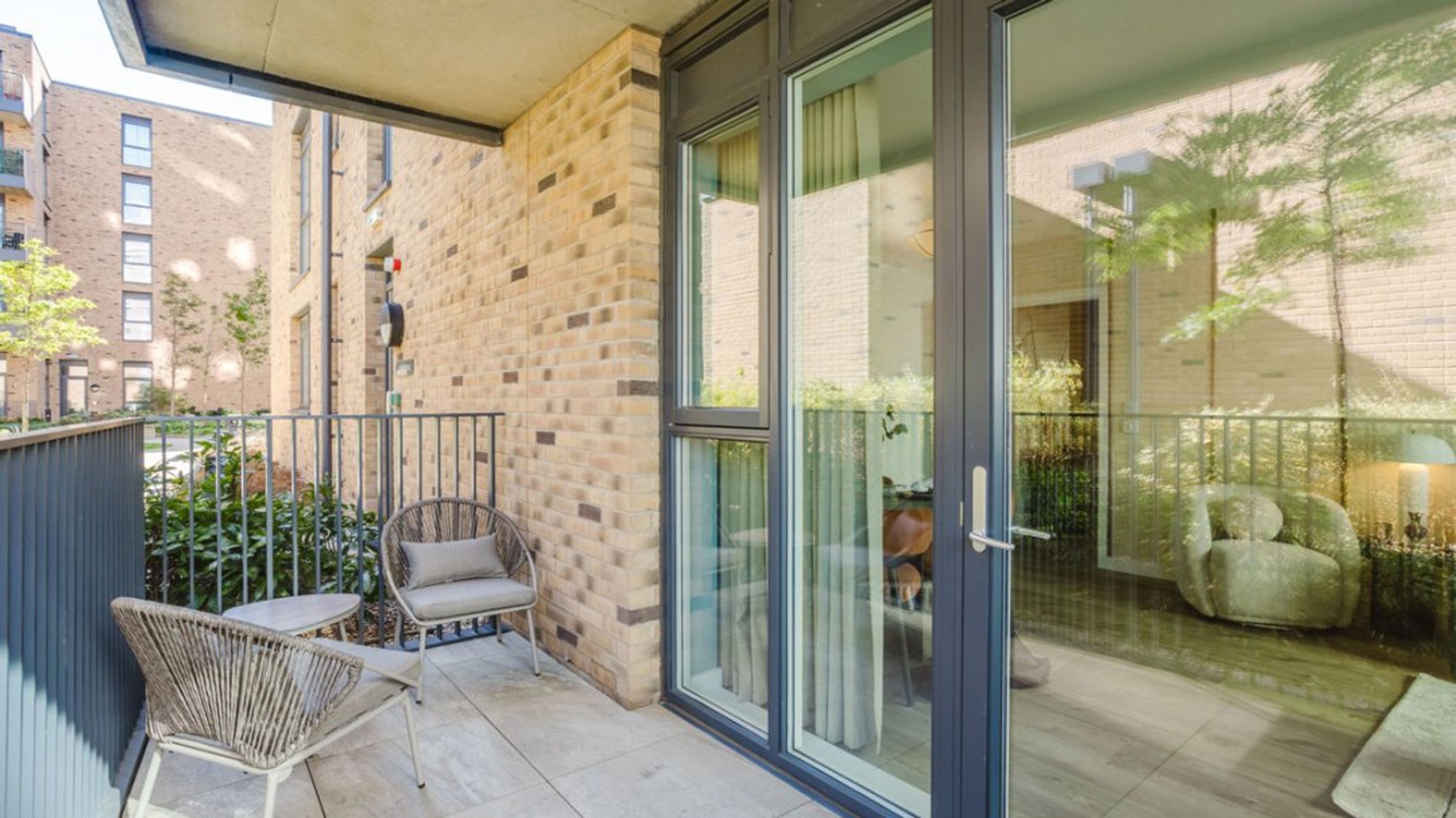 A balcony with two chairs and a small table.