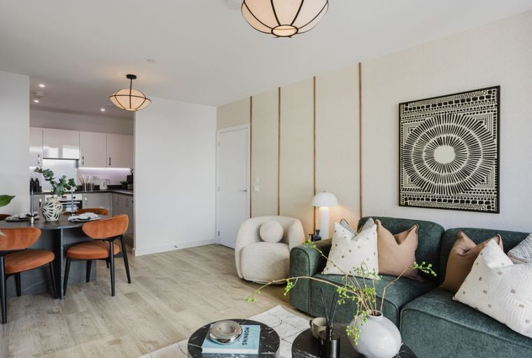 A living room and dining area with a kitchen in the background.