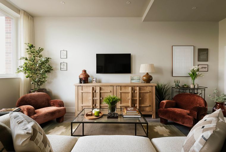 A living room with a media console, two accent chairs, and a coffee table.
