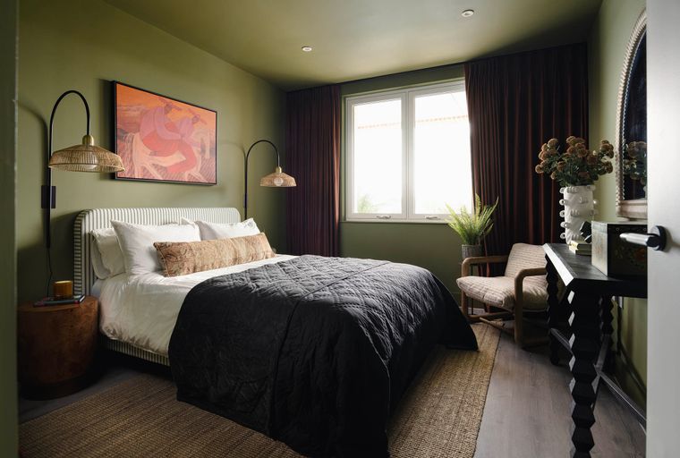 A bedroom with a bed, nightstand, chair, and a window.