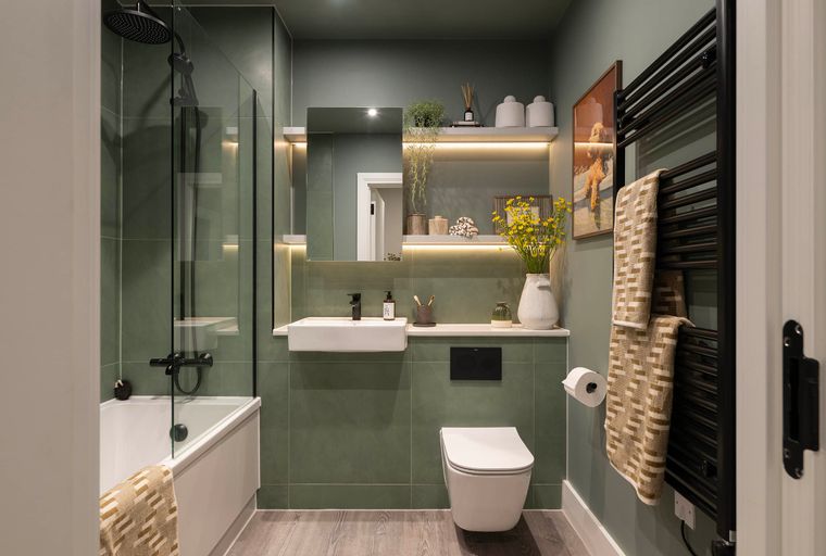 A modern bathroom with a bathtub, shower, sink, and toilet.