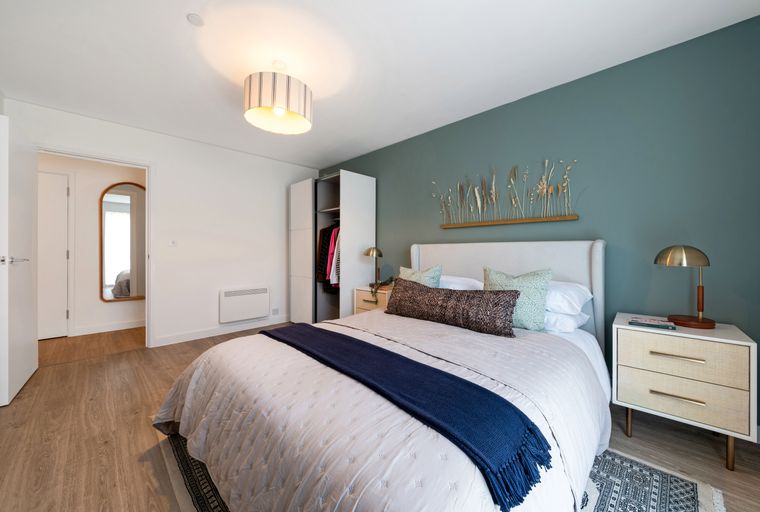 A bedroom with a bed, nightstand, and a closet.