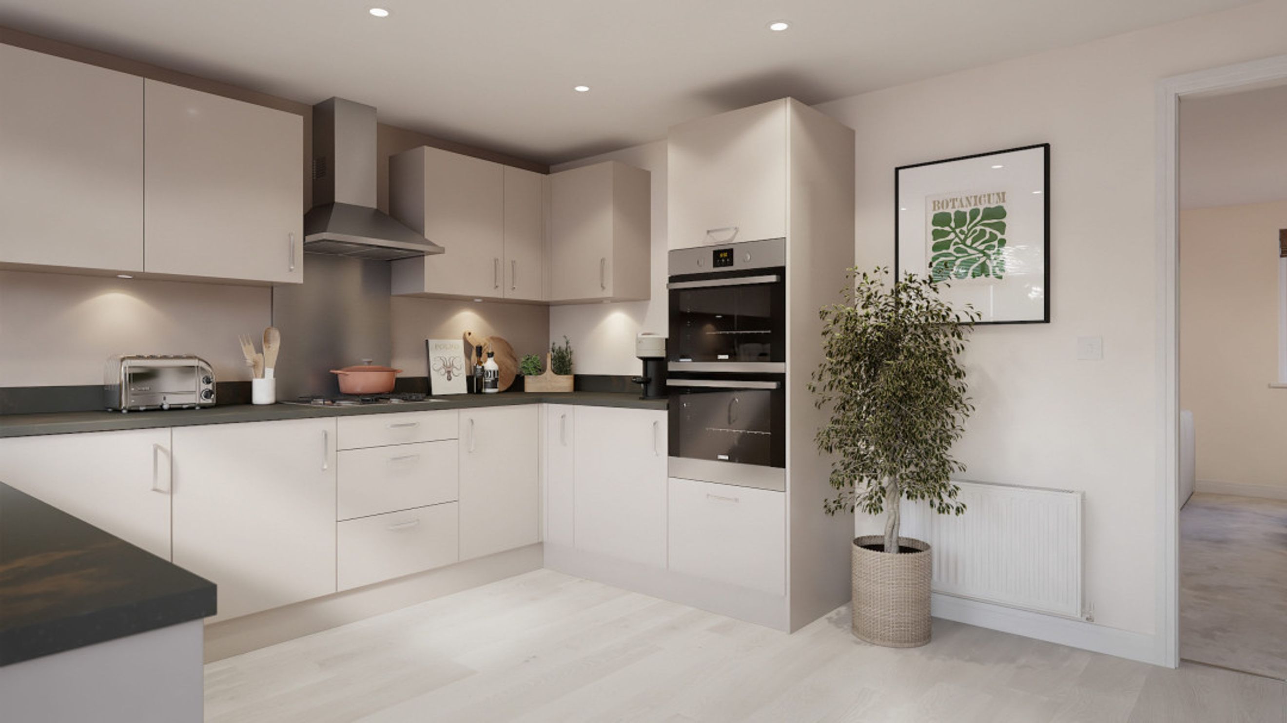 A modern kitchen with light-colored cabinets, built-in ovens, and a toaster.