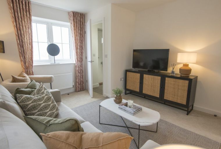 A living room with a sofa, coffee table, and television stand.
