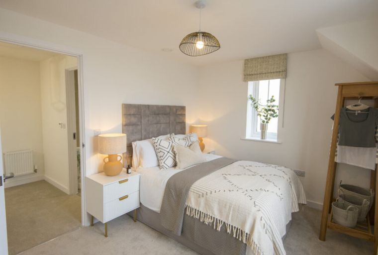 A bedroom with a bed, nightstands, and a window.