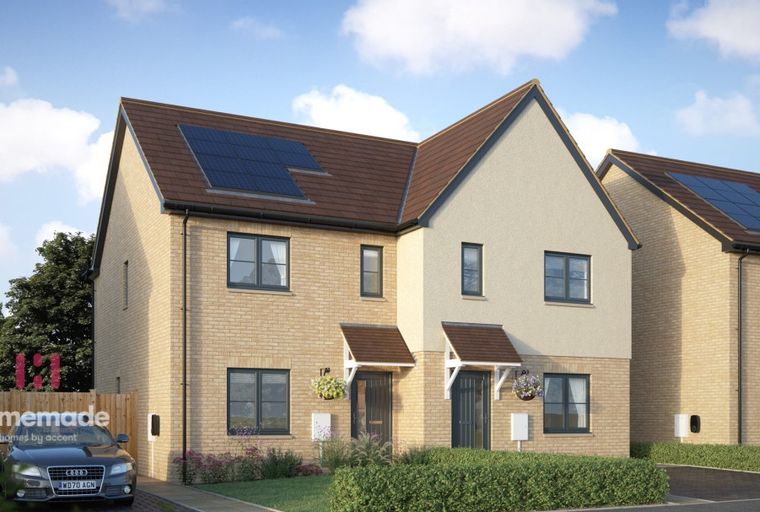 A pair of modern semi-detached houses with solar panels and gardens.