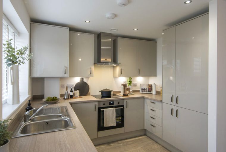 A modern kitchen with sleek cabinets, integrated appliances, and a double sink.