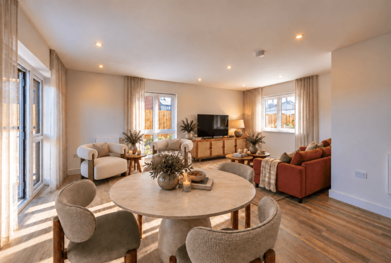 A living and dining room with a round table, chairs, a sofa, and a television.