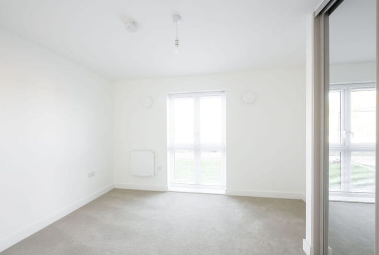 A bedroom with a window and a wardrobe.
