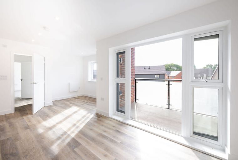 A living room with large windows and a balcony.