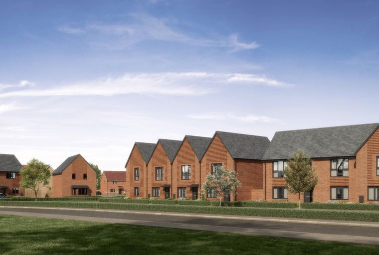A row of modern brick houses with dark roofs under a blue sky.
