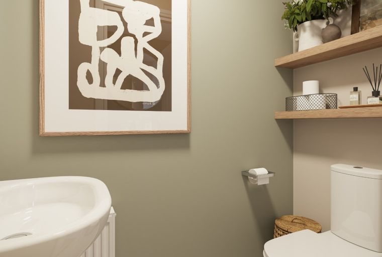 A bathroom with a sink, toilet, and framed artwork.