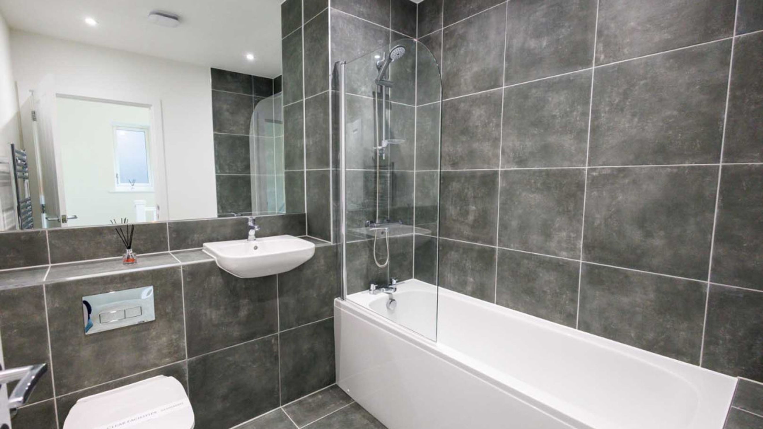 A bathroom with a bathtub, shower, sink, and toilet.