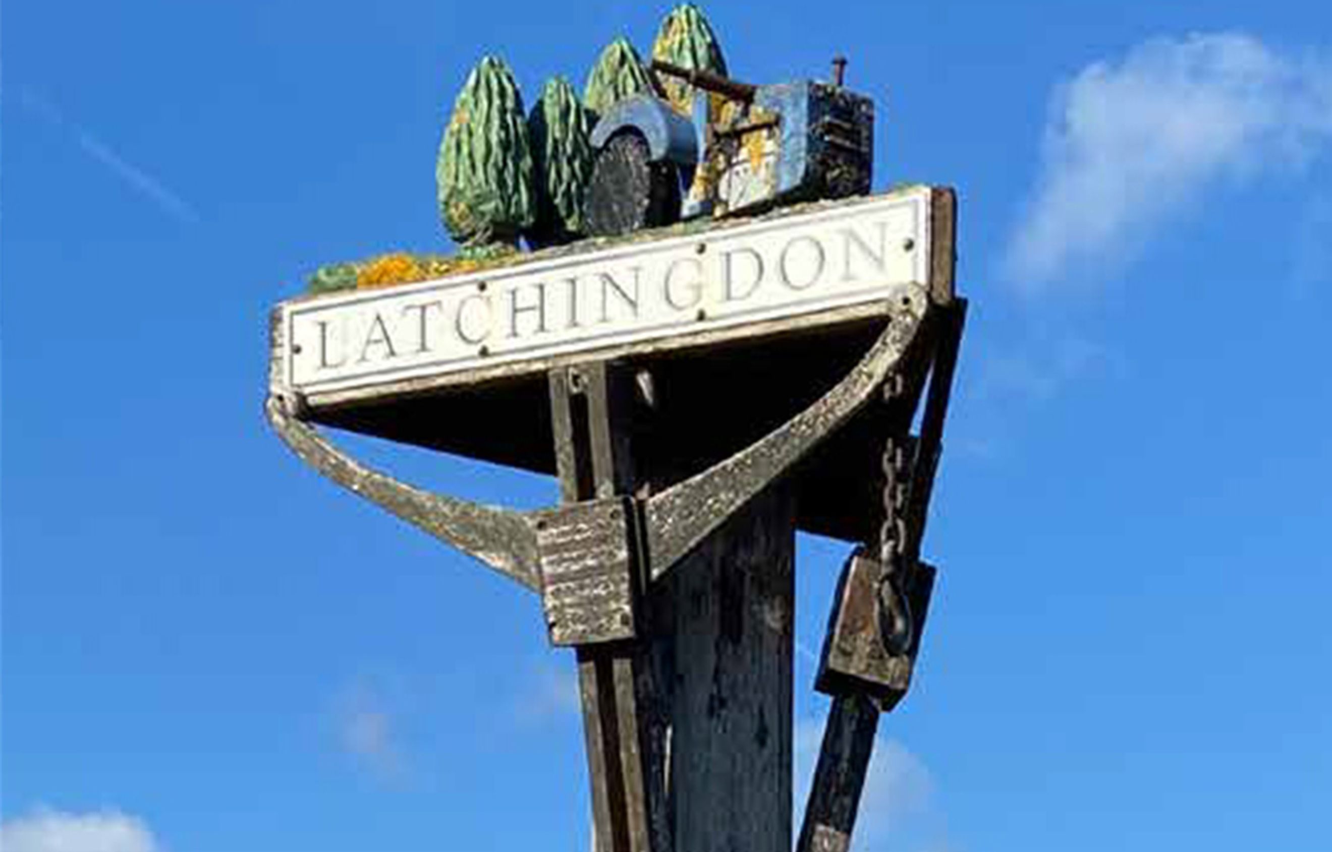 A signpost for Latchingdon with decorative elements on top.