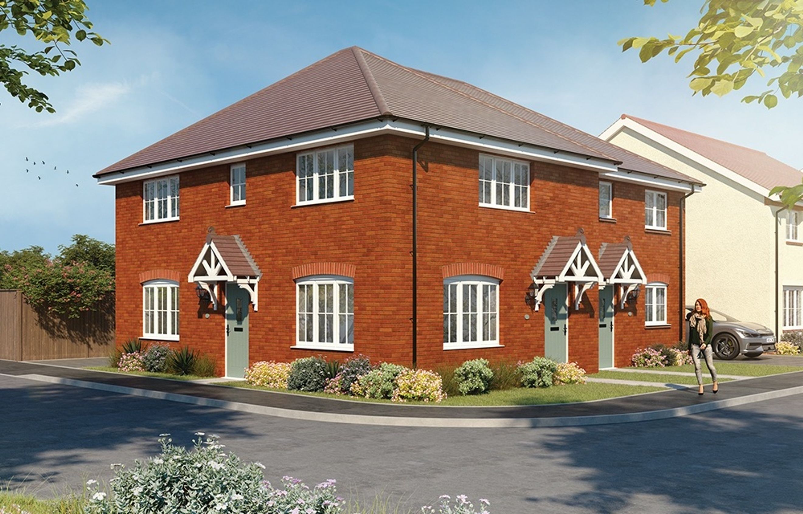 A pair of red brick semi-detached houses with white-framed windows and green doors.