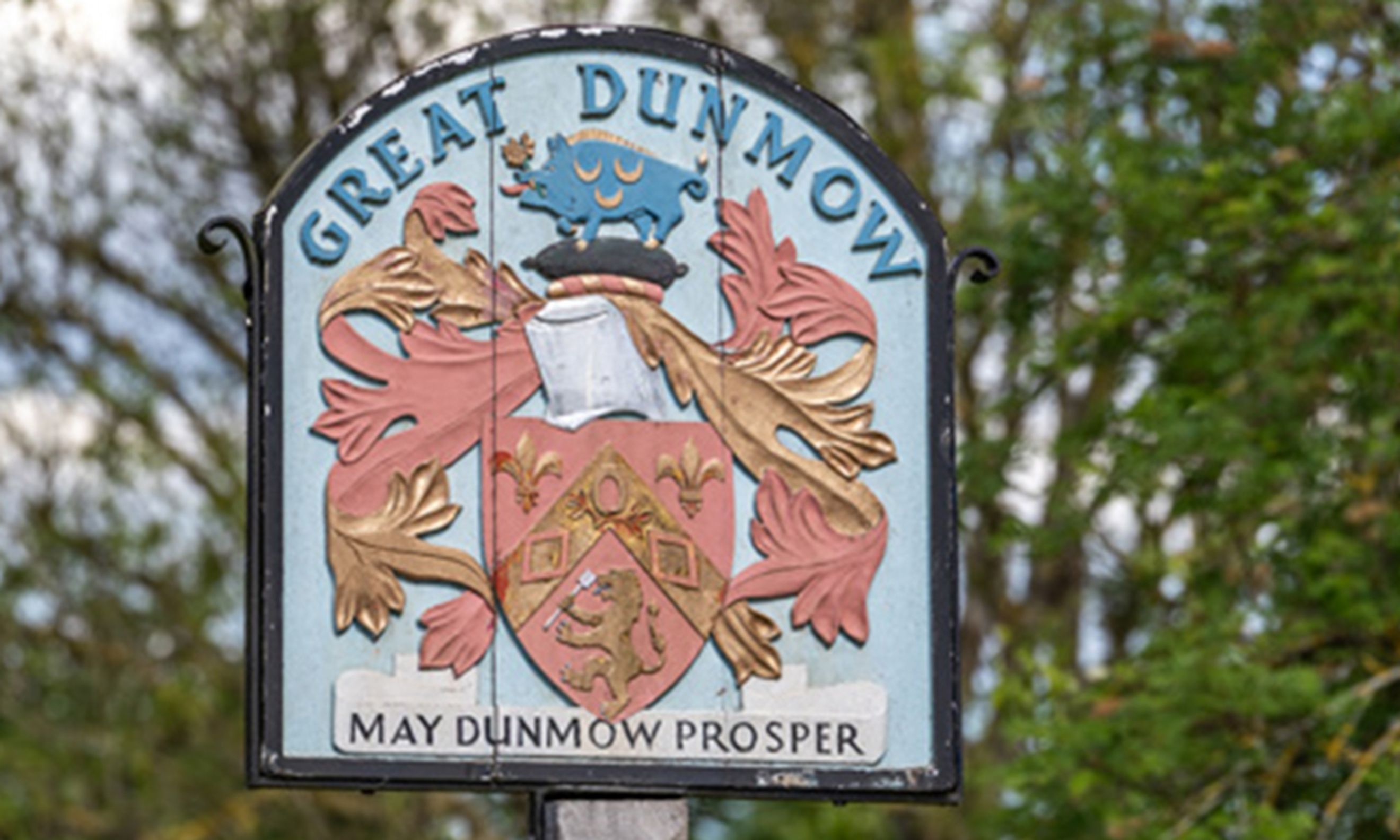 A sign for Great Dunmow with its crest and motto.
